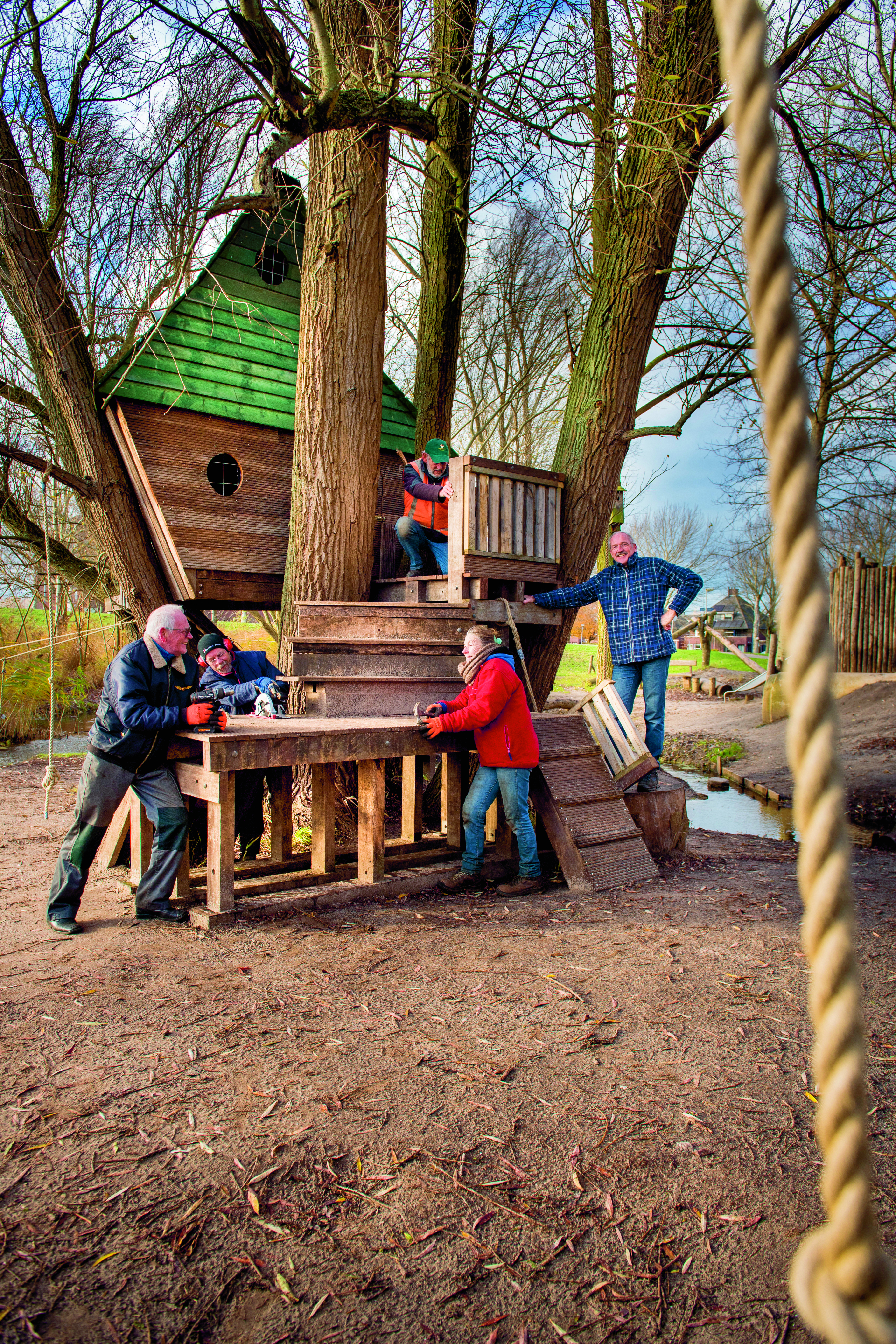 Vijf personen bouwen boomhut